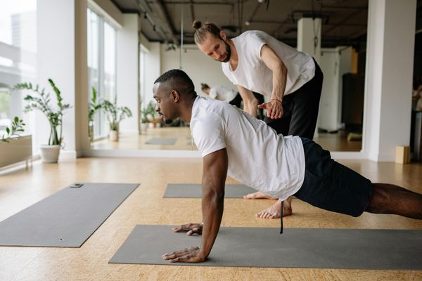 A focused man doing a stretching exercise on a mat.